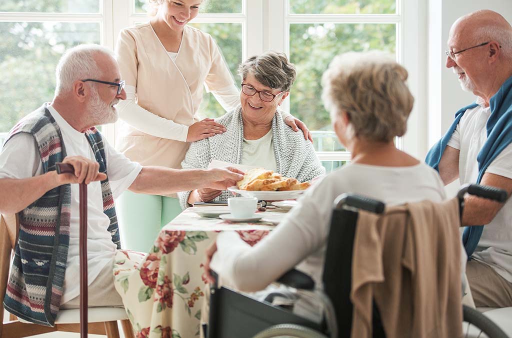 Happy seniors having a cake in a nursing home