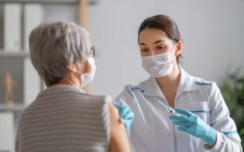 Doctor giving a senior woman vaccination